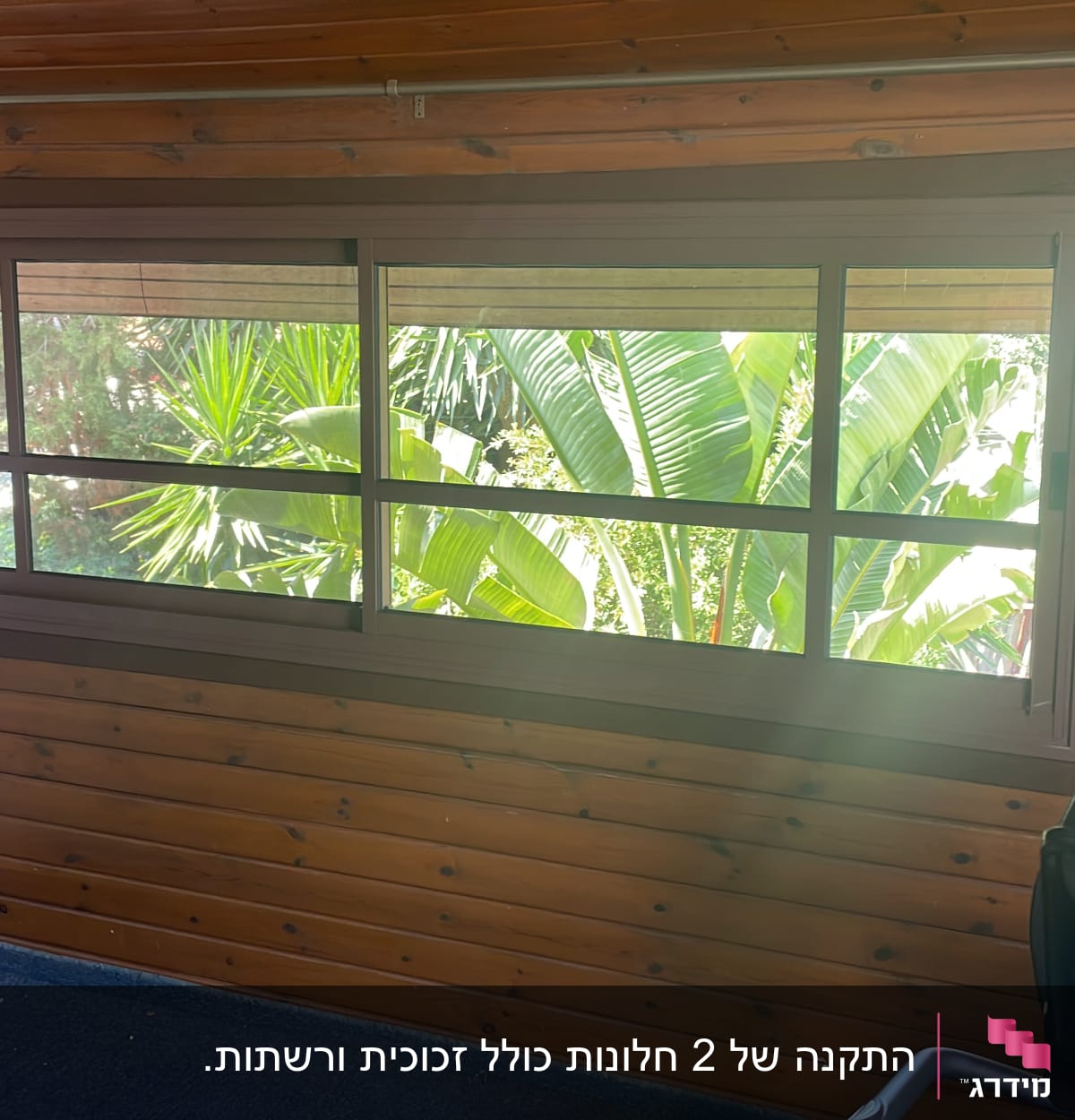 חלון אלומיניום עם מסגרת חומה על קיר עץ